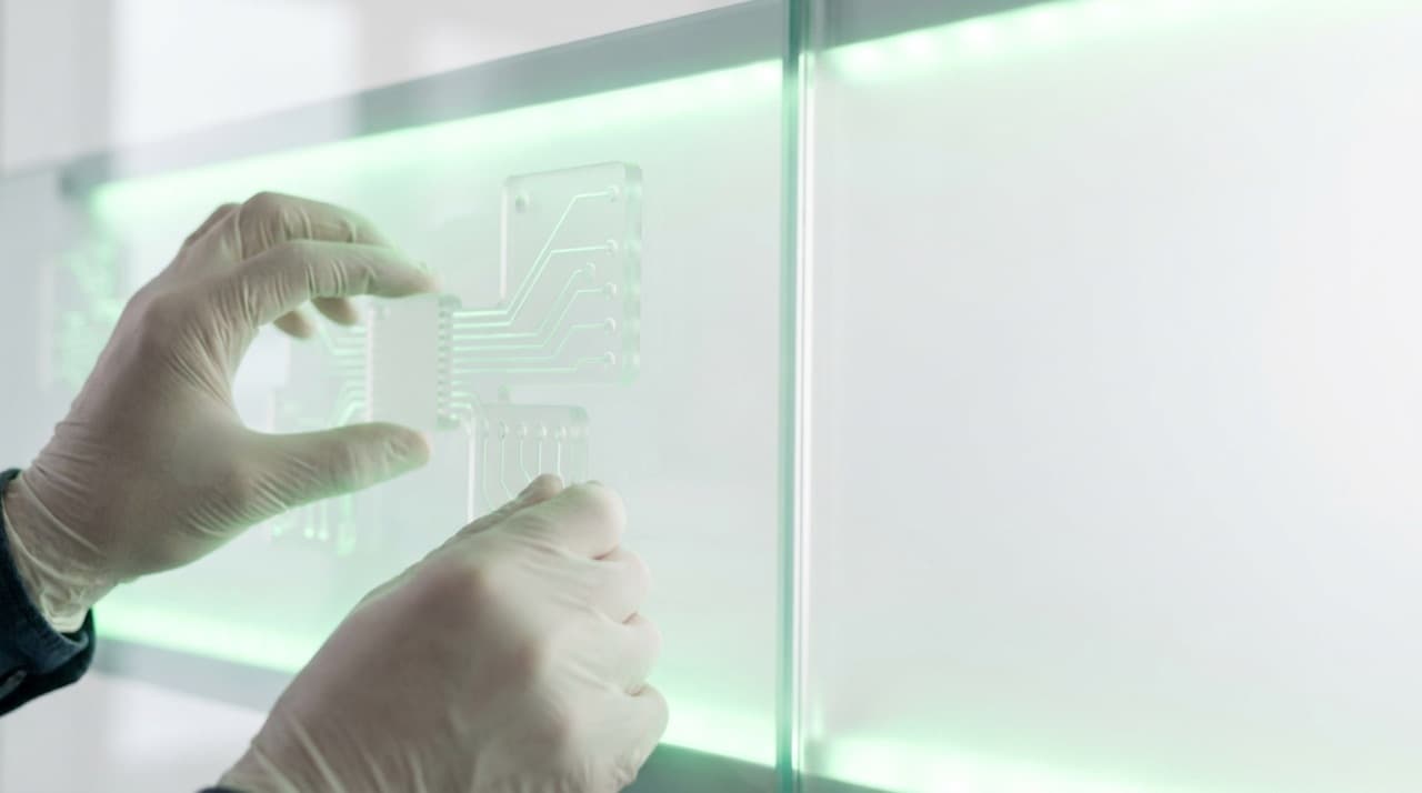 Hands arranging connected flow-node cards on a bright glass wall, lit with a soft green accent